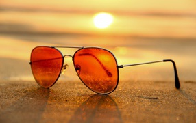 Sunglasses lie on the hot sea sand