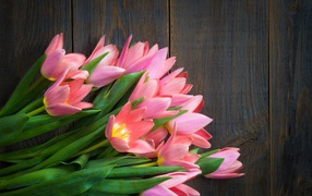 Beautiful bouquet of pink tulips on a wooden table