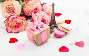 Букет роз на столе с фигуркой Эйфелевой башни и подарком