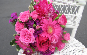 Букет с розовыми цветами георгины, розы, герберы и флоксы на белом стуле