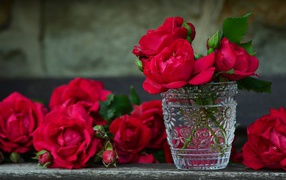 Red roses in a crystal glass on the table