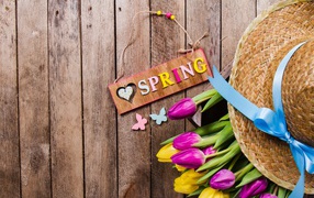 Надпись на английском весна на столе с букетом тюльпанов и шляпой