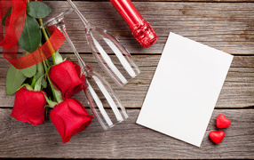 Белый лист бумаги на деревянном столе с бокалами и красными розами
