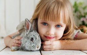 Beautiful blue-eyed girl with a gray rabbit