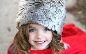 Красивая улыбающаяся девочка в меховой шапке