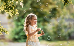 Cheerful girl with soap bubbles