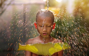 Маленький мальчик азиат умывается водой