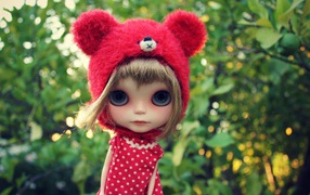 Little doll with big eyes in a red hat