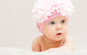 Маленькая девочка в вязаной шапке с цветами