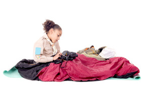 Маленькая девочка в спальном мешке с биноклем