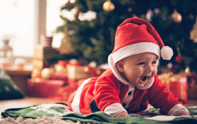 Улыбающийся малыш в новогоднем костюме у елки