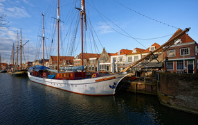 Парусное судно Willem Barentsz с опущенными парусами на причале у домов