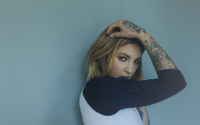 Beautiful girl standing with tattoos on her arm