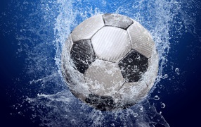 Soccer ball in water on blue background