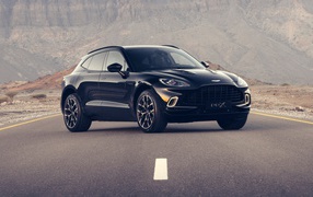 Black aston Martin DBX 2020 car on the track in the mountains