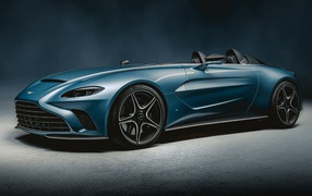 Синий автомобиль Aston Martin V12 Speedster 2020 года на сером фоне