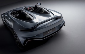 Серебристый автомобиль Aston Martin V12 Speedster 2020 года на сером фоне вид сзади