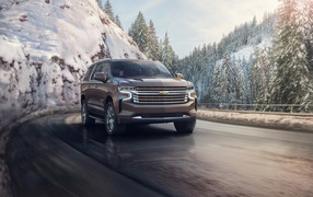 Chevrolet Suburban SUV on the background of a snowy forest, 2021