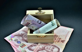 Бумажные деньги на сером фоне с деревянной шкатулкой
