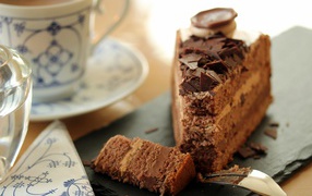Кусок торта с шоколадом на столе с кофе