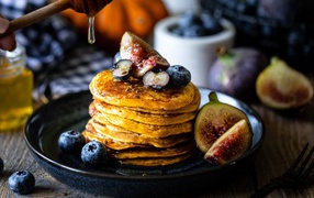 Appetizing pancakes on a plate with blueberries and figs
