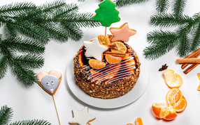 Торт с мандаринами и печеньем на столе с еловой веткой