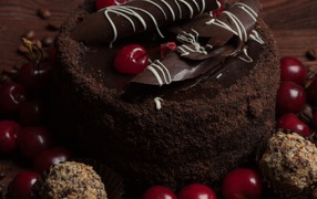 Chocolate cake with sweets and cherries on the table