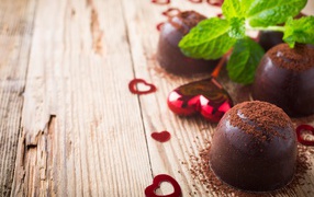 Шоколадные конфеты с какао на столе с мятой и сердечками