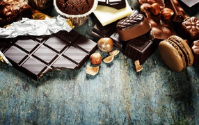 Шоколад на столе с орехами, кексами и конфетами 