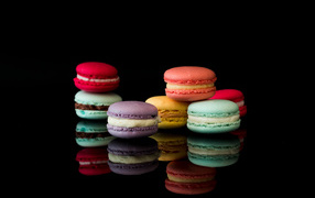 Colorful macaroon dessert on a black background