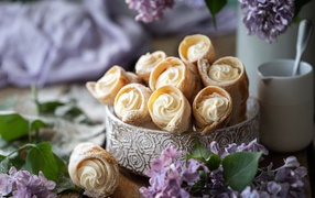 Cream tubes on a table with lilac flowers