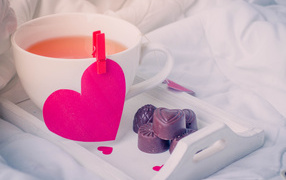Чашка кофе с красным сердцем и шоколадными конфетами 