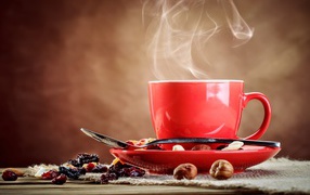 Чашка горячего кофе на столе с сухофруктами