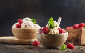 Шарики мороженого в деревянных мисках с ягодами малины