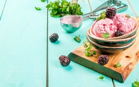 Шарики мороженого на столе с ягодами черники и мятой
