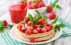 Pancakes with strawberries and cherries on a white plate