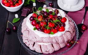 Торт Павлова со сливками и ягодами черешни на столе