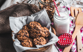 Tasty cookies with chocolate on a table with milk