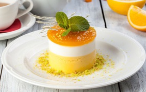 Вкусный десерт с мятой и фисташками на белой тарелке 