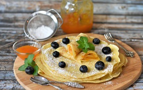 Thin pancakes with apricot jam, mint and blueberries