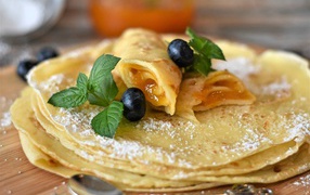 Thin pancakes with jam and blueberries