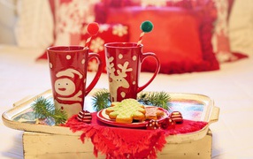 Two red cups with cookies on the table for Christmas