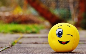 Yellow ball emoticon winks eye