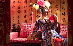 Красивая девушка азиатка в национальном костюме на диване