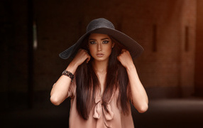 Beautiful brown-eyed brunette in a big hat