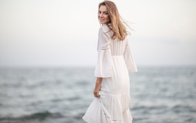 Красивая девушка в белом платье у моря