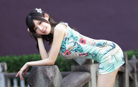 Красивая улыбающаяся девушка азиатка в коротком платье 