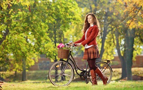 Красивая молодая девушка на велосипеде в парке 