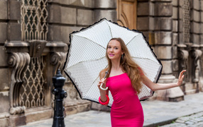 Cute girl in a pink dress with an umbrella in her hands