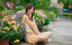 Funny asian girl in dress sits on the ground
